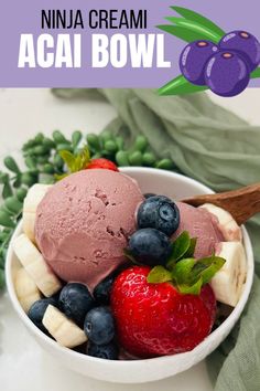 a bowl filled with fruit and ice cream on top of a white table next to green leaves