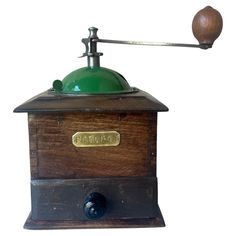 an old fashioned coffee grinder with a green dome on it's top and handle