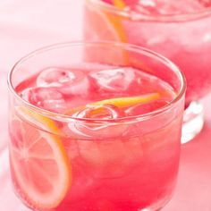 two glasses filled with watermelon and lemonade on top of a pink table