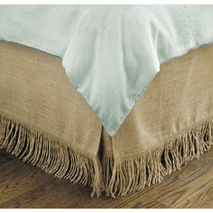 a close up view of a bed with fringed linens on the bottom and sides