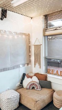 a living room with a couch, ottoman and large window