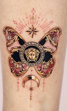 a woman's thigh with tattoos on it and an image of a face in the middle