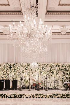 an elegant wedding setup with white flowers and chandelier