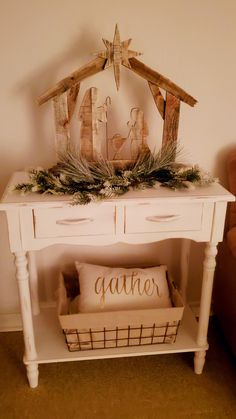 a small white table with a nativity scene on top and a basket under it