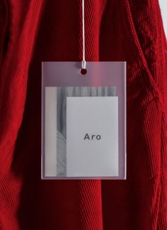 an ornament hanging from a red sweater with the word aro on it