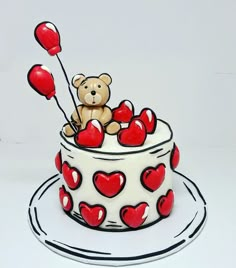 a cake decorated with hearts and a teddy bear