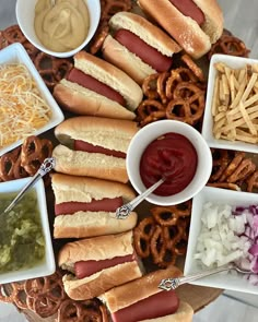 a platter with hot dogs, pretzels, onion rings and other condiments