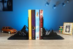 three books are stacked on top of each other in front of a toy car and photo frame