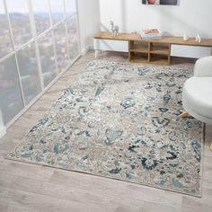 a living room with a large rug on the floor next to a chair and table