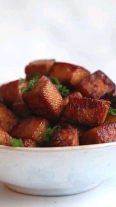 a white bowl filled with fried food on top of a table