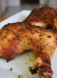 two pieces of chicken sitting on top of a white plate