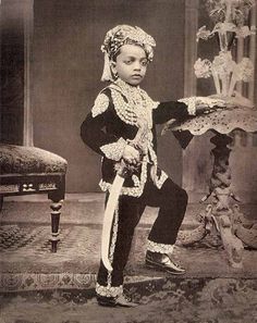 an old photo of a young boy dressed in costume