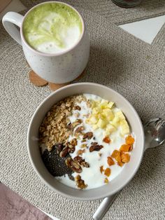 a bowl of granola, yogurt, and fruit next to a cup of coffee