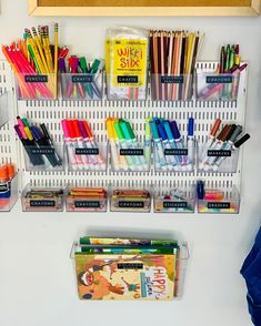 the wall is filled with school supplies and pens, pencils, markers, and books