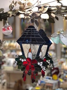 a stained glass lantern hanging from a ceiling in a store filled with christmas decorations and ornaments