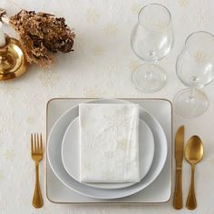 a place setting with white plates and silverware