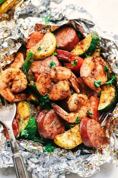 shrimp, zucchini and potatoes in foil with a fork on the side for garnish