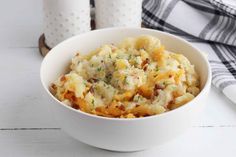 a white bowl filled with mashed potatoes on top of a table