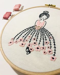 a woman in a pink dress with flowers on it's back is embroidered onto a hoop