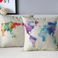 two pillows with watercolor world map on them