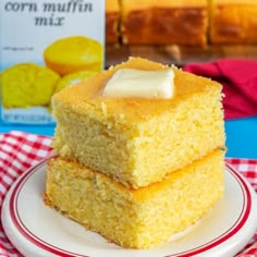 two pieces of cornbread on a plate with a carton of jelly in the background