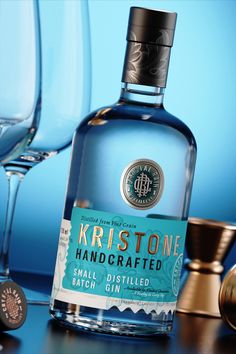 a bottle of krst stone handcrafted gin sitting next to two wine glasses