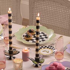 the table is set with plates, cups, and candles for desserts to be eaten