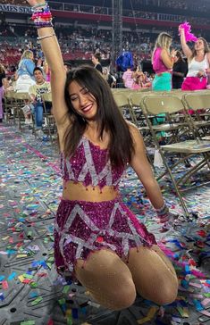 a woman in a purple dress is sitting on the floor with confetti all around her