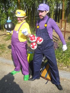 two people dressed in costumes standing next to each other on the side of the road