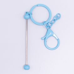 a pair of scissors and a hook on a white surface