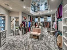 a large walk in closet with lots of clothes