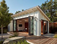 a small white house with a wooden deck