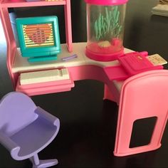 there is a toy desk with a computer on it and a chair next to it