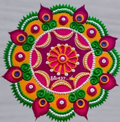 an intricately designed rangdi work with colorful flowers and leaves on white wooden background