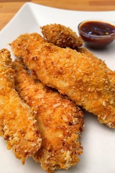 some fried food on a white plate with dipping sauce