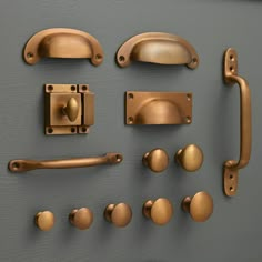 an assortment of door handles and knobs on a gray surface with gold colored hardware