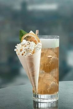 two drinks sitting on top of a table next to each other with ice and lemon wedges