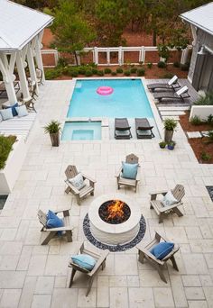 an aerial view of a fire pit surrounded by lawn chairs and loungers next to a swimming pool