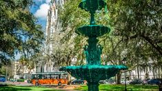 a green fountain in the middle of a park