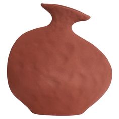 a brown vase sitting on top of a white table