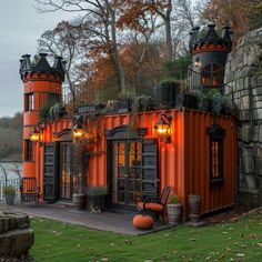 an orange building with lots of windows and lights on the outside, next to a body of water