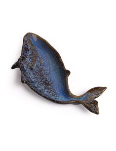 a blue fish shaped object sitting on top of a white surface