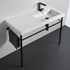 a white sink sitting on top of a black and white counter next to a wall