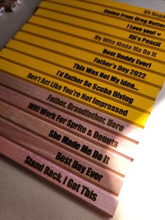 several pencils with words on them sitting on a table next to some paper and scissors