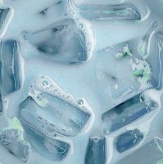 ice cubes with water bubbles and green leaves on the top, as seen from above