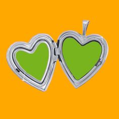 two heart shaped lockes with green frames on an orange and yellow background stock photo