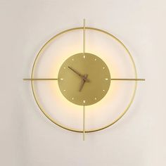 a clock that is on the side of a wall with lights around it and in front of a white wall