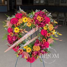 a memorial wreath with flowers and an arrow