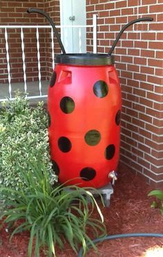 a red and black ladybug planter sitting next to a brick building