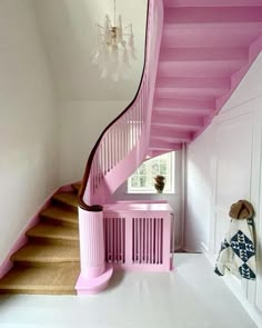 a pink staircase in a white room with chandelier